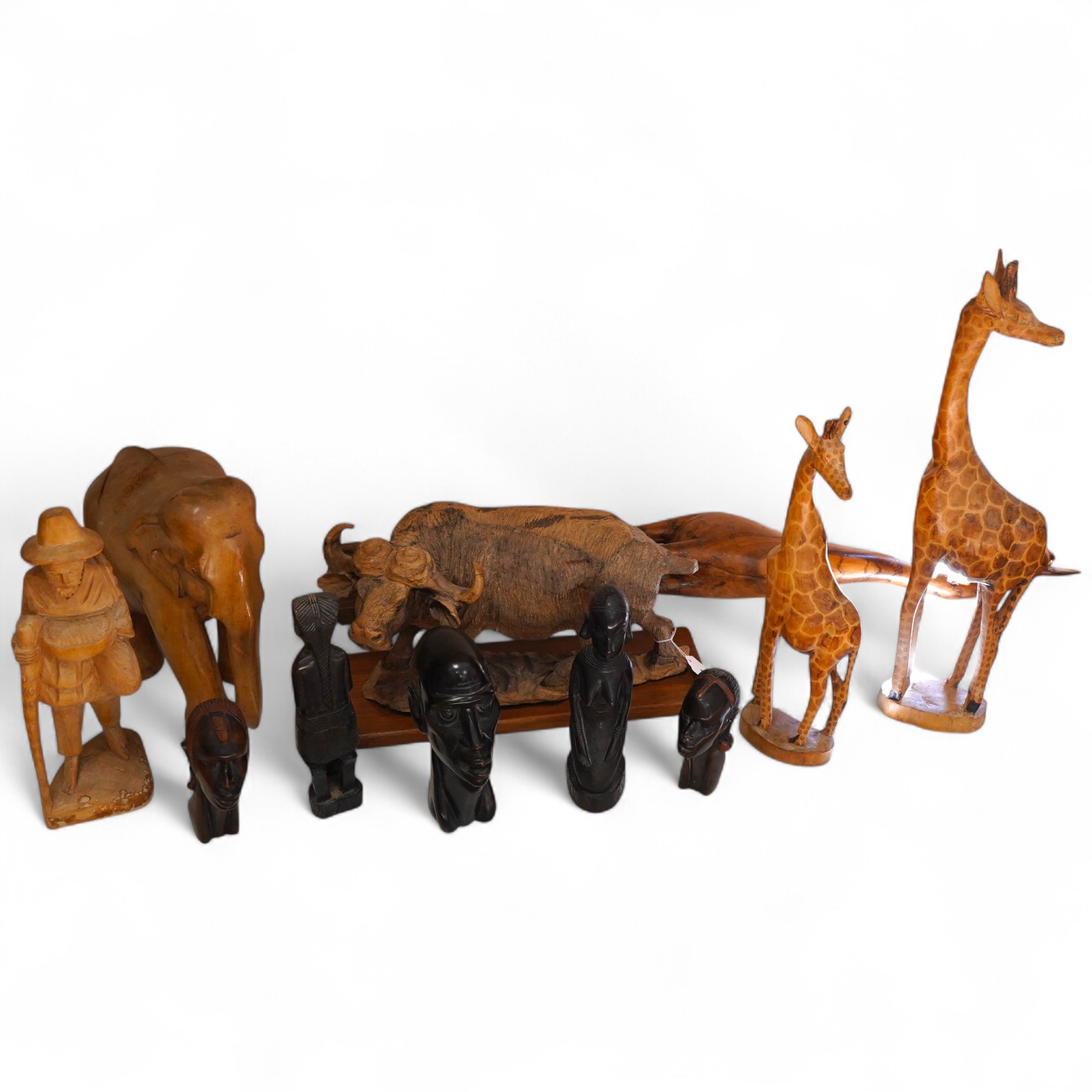 A collection of mostly Eastern and African carved wood figures to include three giraffes, a buffalo and African busts
